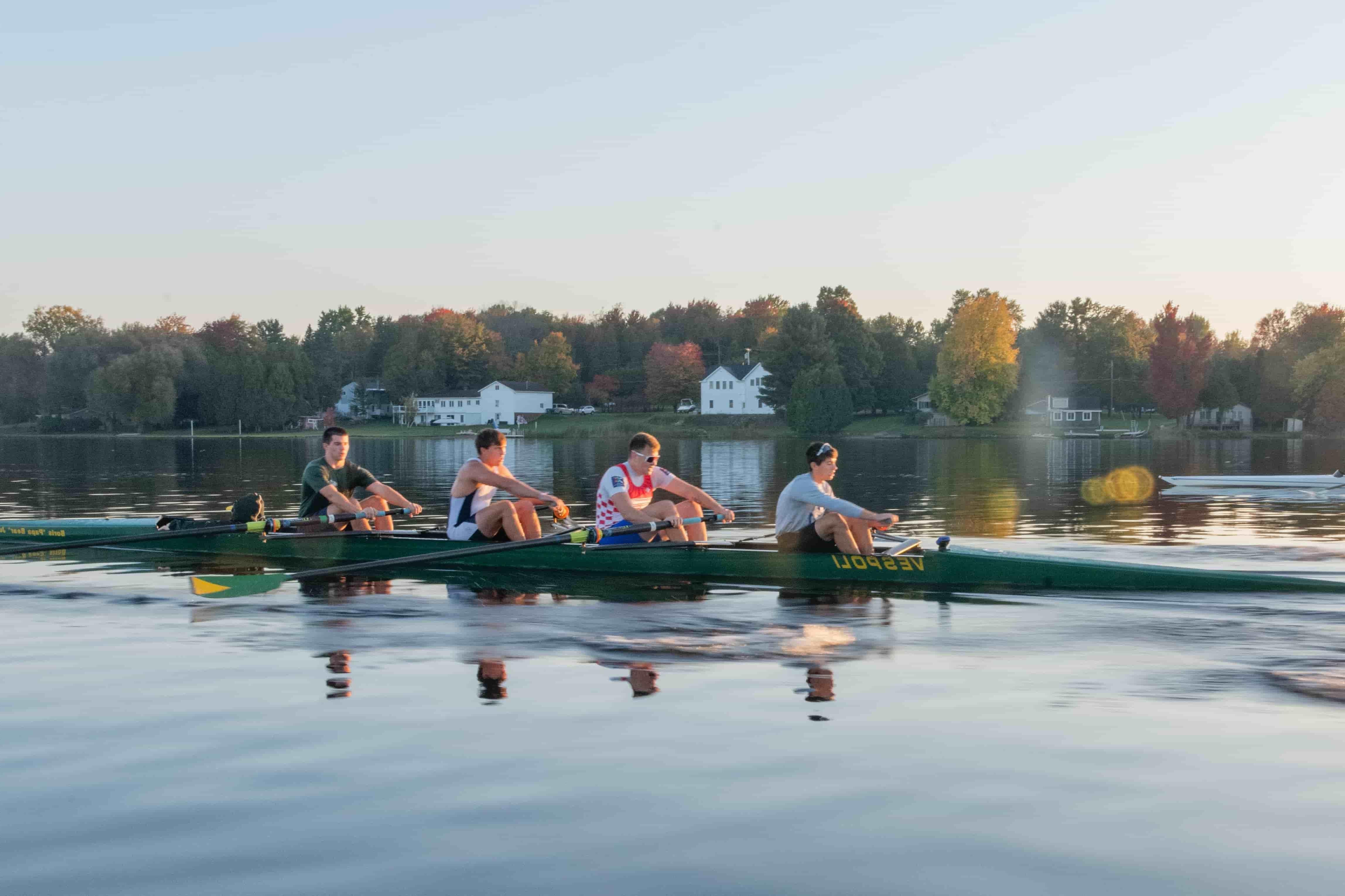 The Clarkson CREW team rows on a scenic body of water